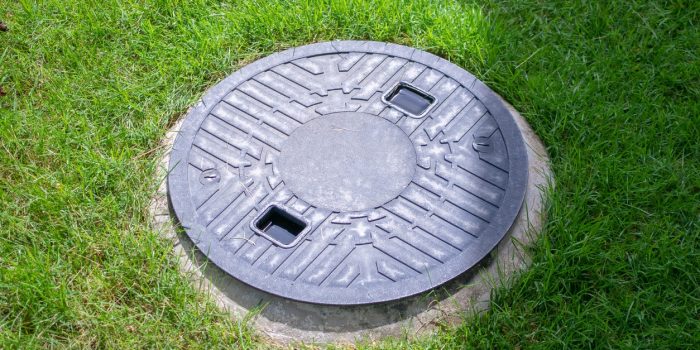 Grey Septic Tank Cover Near Green Grass